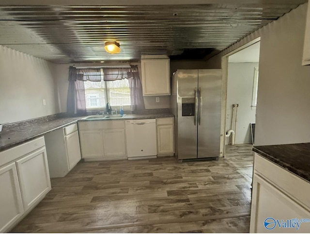 kitchen featuring sink, hardwood / wood-style floors, stainless steel fridge, and white dishwasher