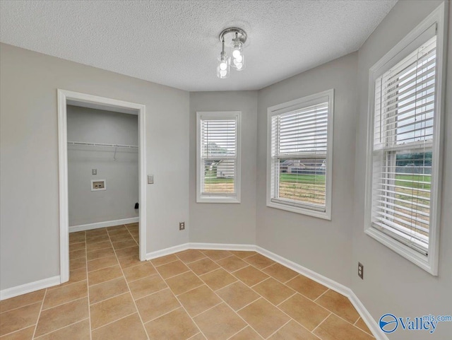 323 Earnhardt Dr, New Market, AL 35761 - unfurnished dining area featuring light tile patterned flooring, a textured ceiling, and baseboards