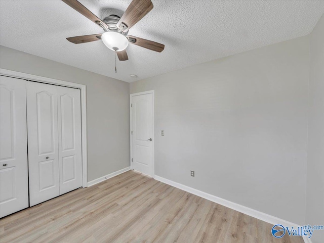 323 Earnhardt Dr, New Market, AL 35761 - unfurnished bedroom with light wood-type flooring, a closet, baseboards, ceiling fan, and a textured ceiling