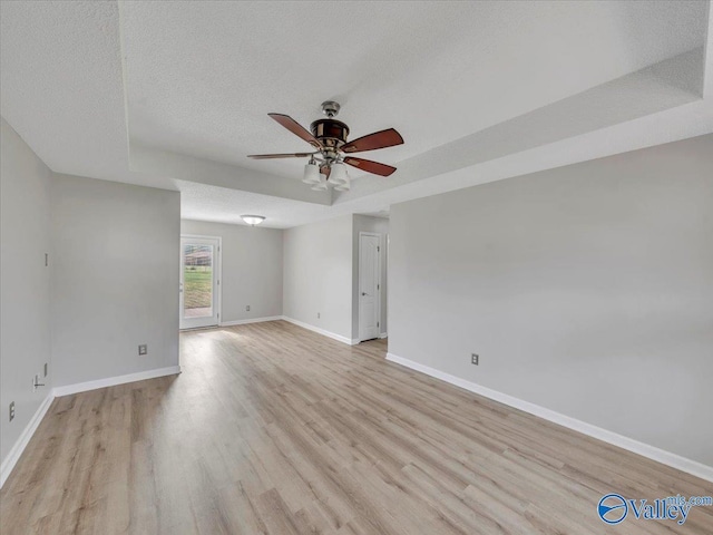 323 Earnhardt Dr, New Market, AL 35761 - spare room with a ceiling fan, light wood-style flooring, a textured ceiling, a raised ceiling, and baseboards
