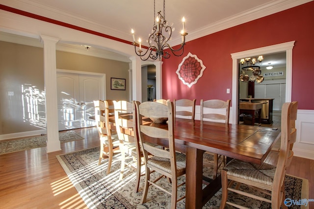 dining area with arched walkways, wood finished floors, ornamental molding, and ornate columns