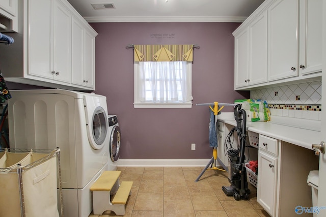 washroom featuring visible vents, crown molding, washer and dryer, light tile patterned flooring, and cabinet space