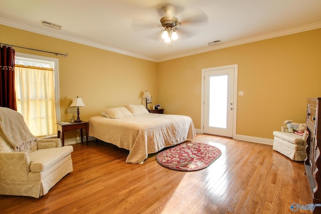 bedroom with visible vents, crown molding, and light wood-type flooring