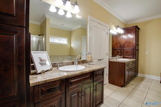 bathroom with tile patterned floors, ornamental molding, two vanities, and a sink