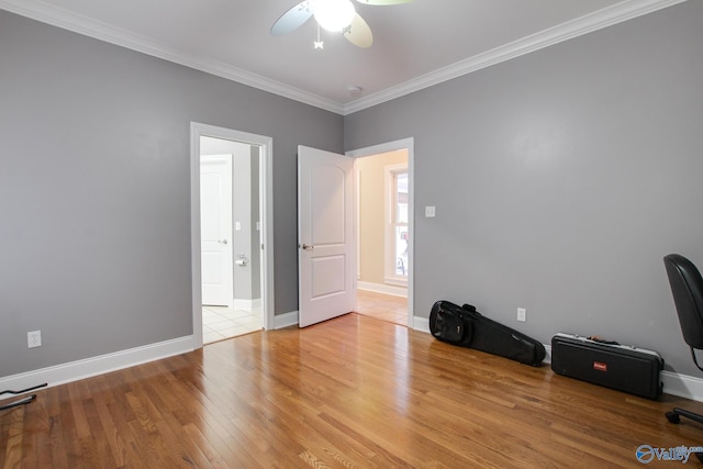 unfurnished room featuring ceiling fan, light wood-type flooring, baseboards, and ornamental molding