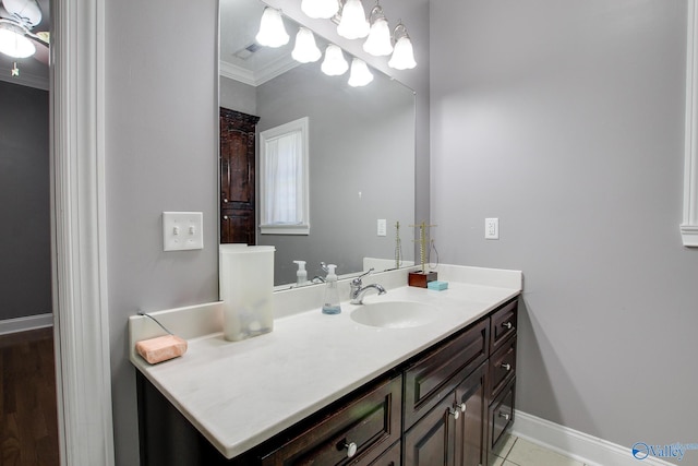 bathroom featuring visible vents, crown molding, baseboards, tile patterned floors, and vanity