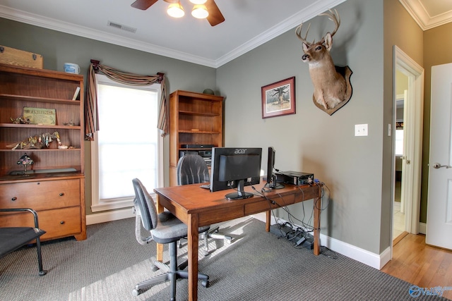 home office with visible vents, ornamental molding, light wood-style floors, baseboards, and ceiling fan