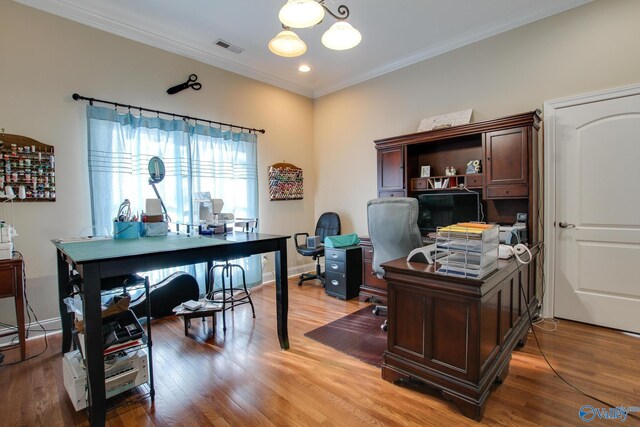 office area featuring crown molding, light wood-style floors, visible vents, and baseboards