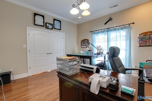 office with visible vents, ornamental molding, light wood-style flooring, baseboards, and a chandelier