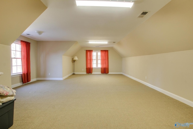 additional living space featuring lofted ceiling, carpet, visible vents, and baseboards