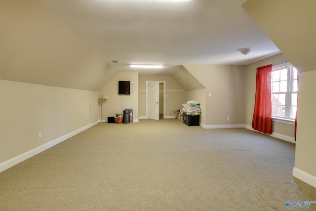 additional living space with carpet, lofted ceiling, and baseboards