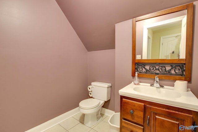half bathroom featuring vanity, baseboards, tile patterned flooring, vaulted ceiling, and toilet