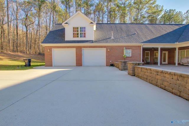 view of front of home featuring concrete driveway, a garage, brick siding, and roof with shingles
