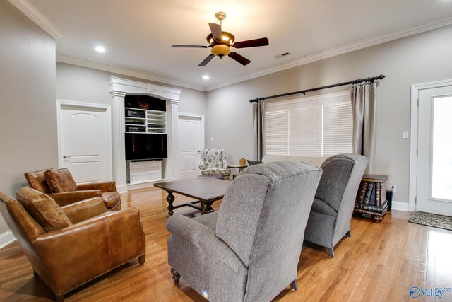 living room with light wood finished floors, baseboards, ceiling fan, and ornamental molding