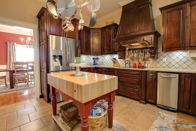 kitchen featuring wooden counters, crown molding, stainless steel fridge with ice dispenser, premium range hood, and an inviting chandelier
