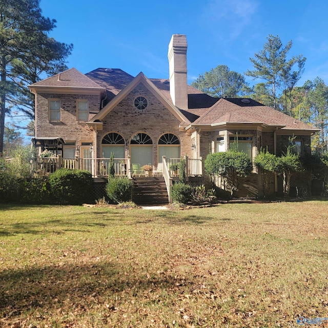 back of property with a lawn and covered porch