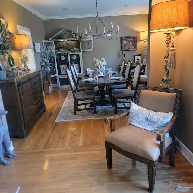 dining area with ornamental molding, a chandelier, and light wood-type flooring