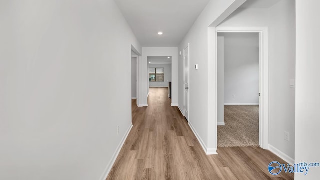 hallway with light hardwood / wood-style floors