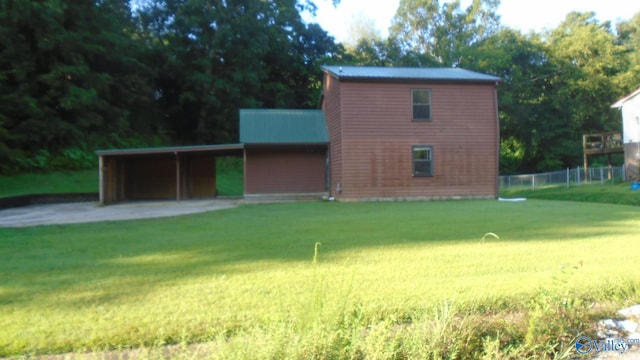 exterior space featuring metal roof, a carport, and a front yard