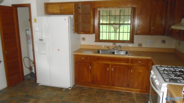kitchen featuring white appliances, range hood, light countertops, and a sink