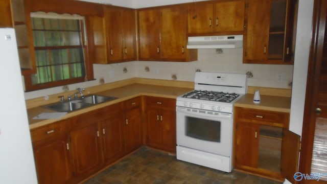 kitchen with under cabinet range hood, white appliances, a sink, and light countertops