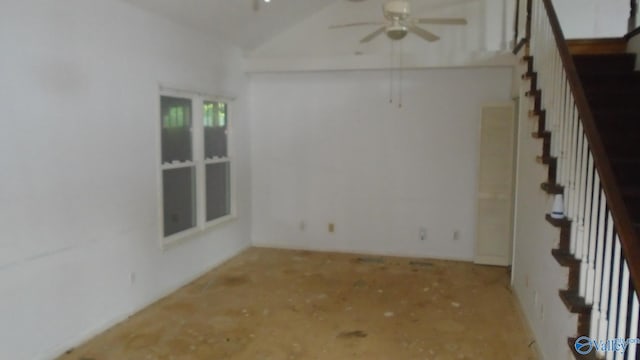 spare room with a ceiling fan, lofted ceiling, and stairway