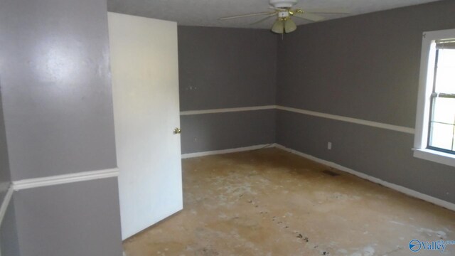 empty room featuring plenty of natural light, baseboards, and ceiling fan