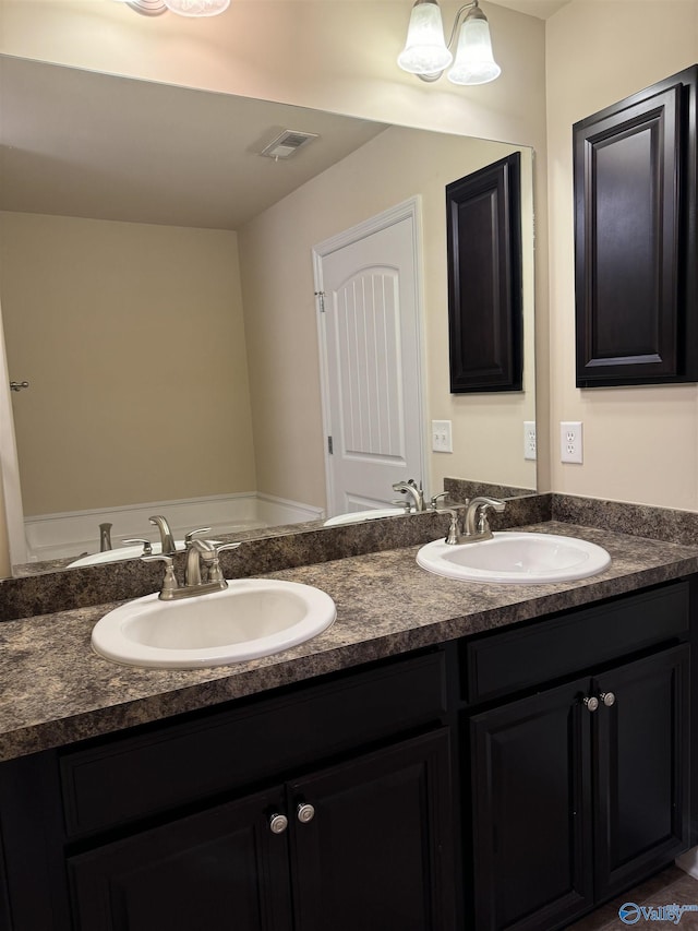 bathroom with double vanity, visible vents, and a sink