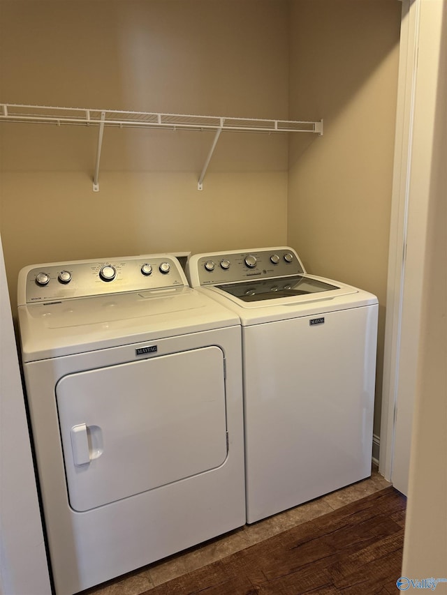 laundry room with separate washer and dryer, dark wood-style floors, and laundry area