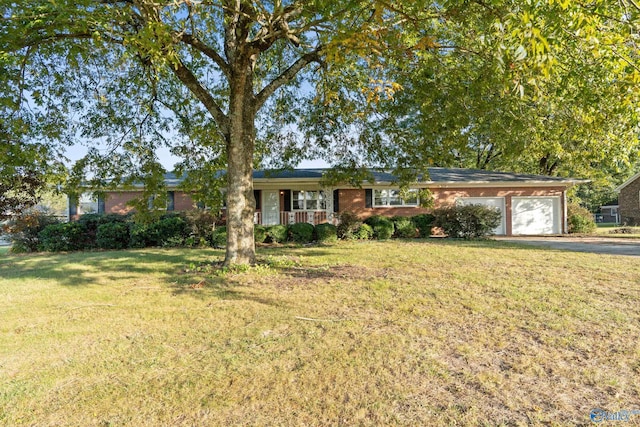 ranch-style home featuring a front yard, a garage, and a porch