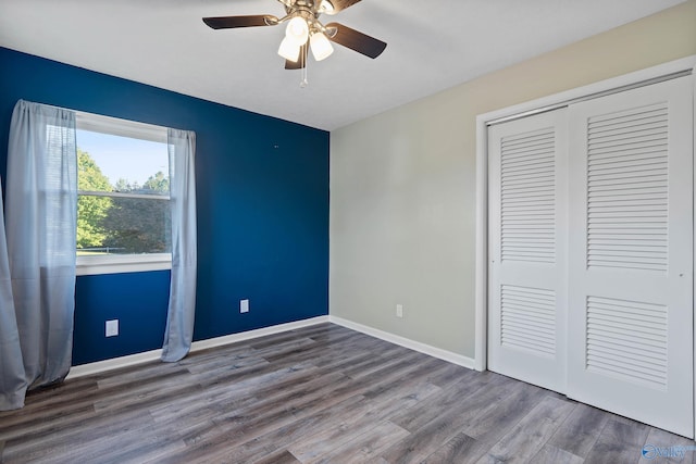 unfurnished bedroom with a closet, ceiling fan, and hardwood / wood-style floors