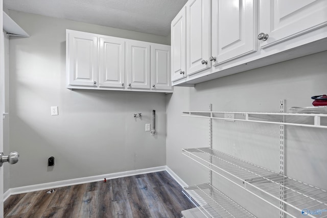 clothes washing area with hookup for a washing machine, cabinets, dark wood-type flooring, and a textured ceiling