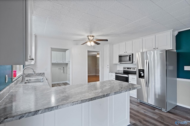 kitchen with ceiling fan, sink, white cabinetry, appliances with stainless steel finishes, and dark hardwood / wood-style floors