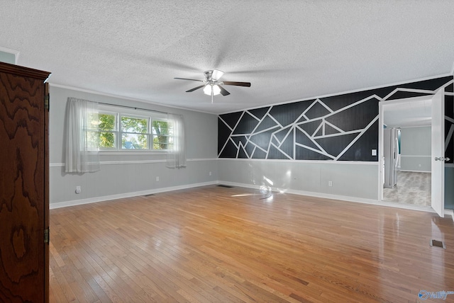 empty room featuring ceiling fan, hardwood / wood-style floors, and a textured ceiling