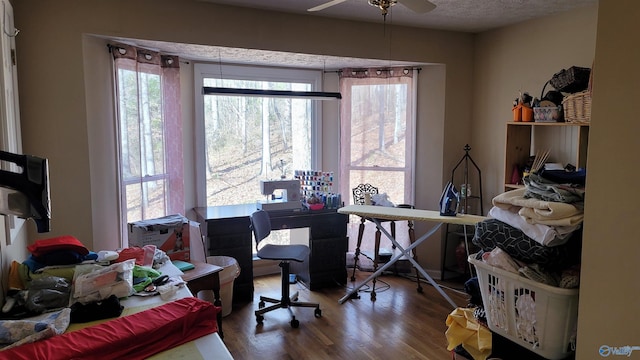 home office featuring ceiling fan, a textured ceiling, and wood finished floors