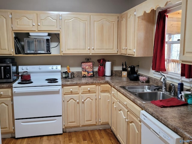 kitchen featuring light brown cabinets, white appliances, a sink, and light wood-style flooring