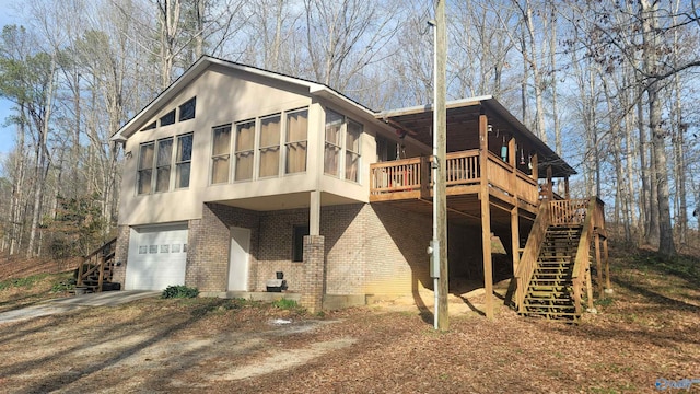 back of property featuring crawl space, driveway, stairway, and brick siding