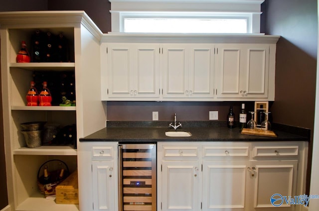 bar with beverage cooler, wet bar, and a sink