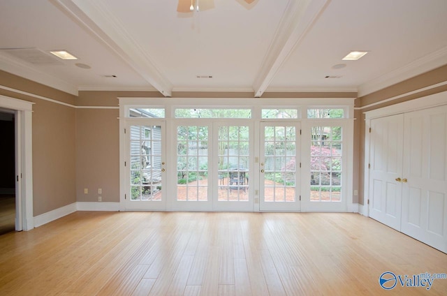 interior space with beam ceiling, a wealth of natural light, and wood finished floors