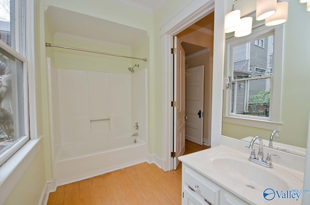 full bathroom with washtub / shower combination, ornamental molding, wood finished floors, and vanity