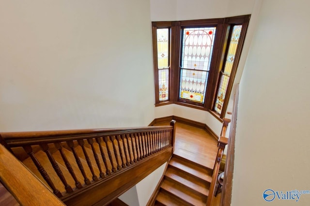 stairway featuring wood finished floors and baseboards