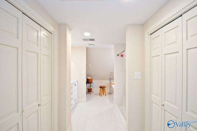 hallway featuring visible vents and baseboards