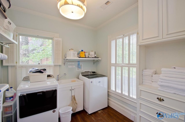 washroom featuring cabinet space, visible vents, washer and clothes dryer, dark wood-type flooring, and crown molding