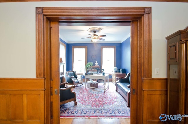 interior space featuring ceiling fan, wood finished floors, and crown molding