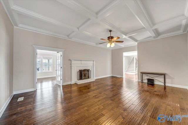 unfurnished living room featuring dark wood-type flooring, coffered ceiling, beamed ceiling, ceiling fan, and a fireplace