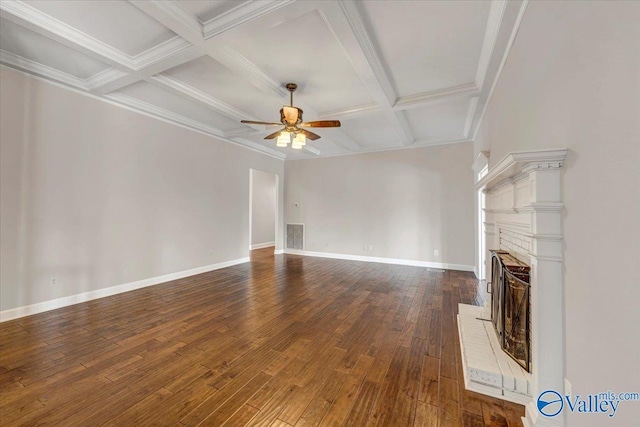 unfurnished living room featuring ceiling fan, beam ceiling, dark hardwood / wood-style floors, coffered ceiling, and ornamental molding