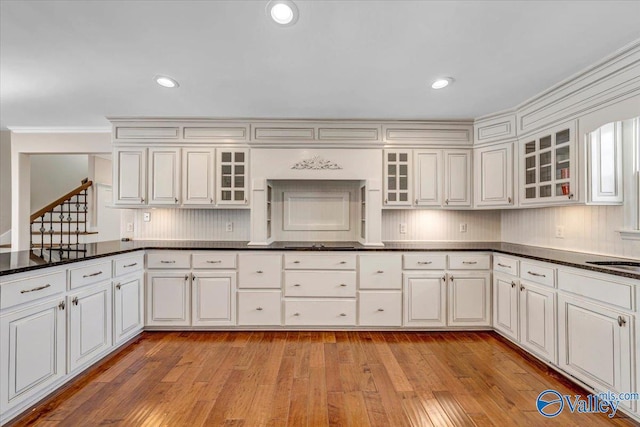 kitchen featuring white cabinetry, sink, decorative backsplash, and light wood-type flooring