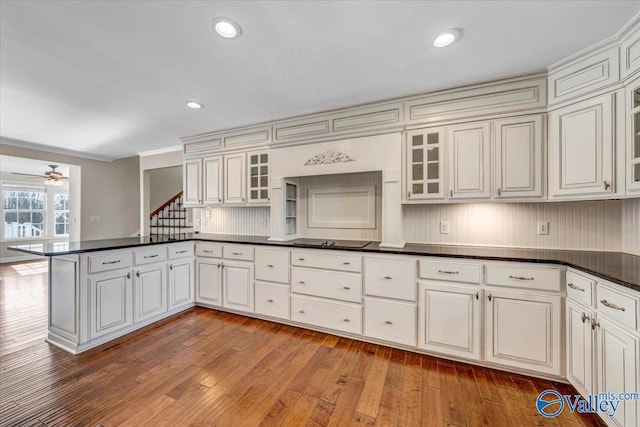kitchen featuring black electric cooktop, white cabinets, light hardwood / wood-style floors, and kitchen peninsula