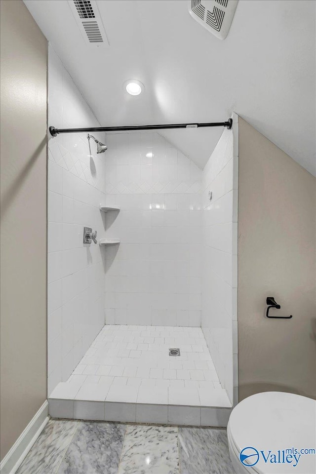 bathroom featuring toilet and a tile shower