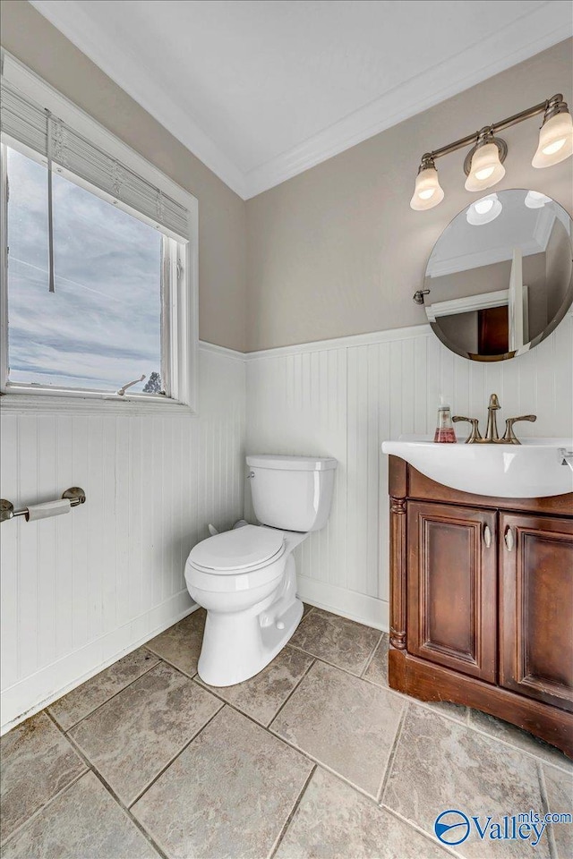 bathroom with ornamental molding, vanity, and toilet